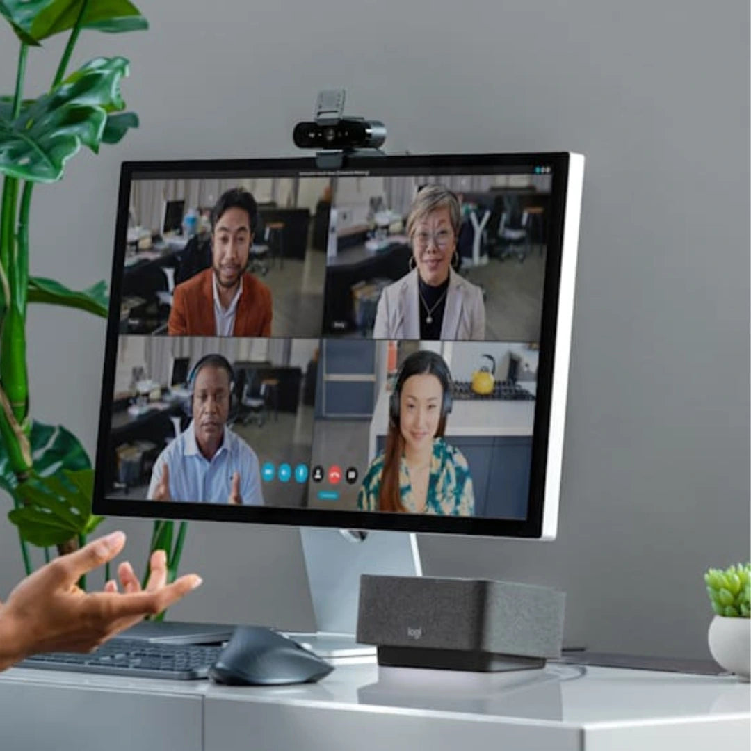 Webcam Logitech BRIO 4K HDR en uso sobre monitor durante videollamada, pensada para trabajo remoto y reuniones profesionales