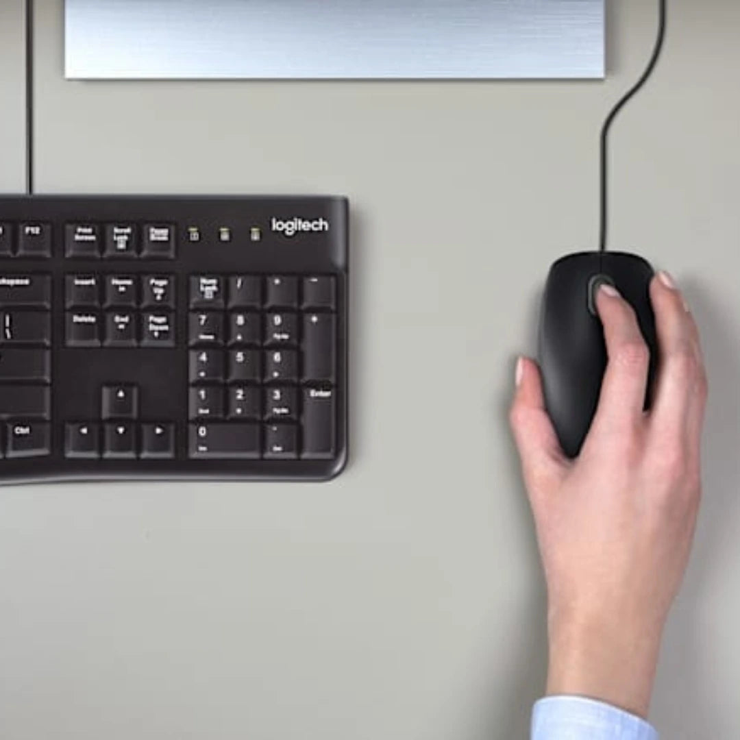 Combo Logitech MK120 en uso sobre escritorio, mostrando el mouse y parte del teclado para un setup profesional plug and play.